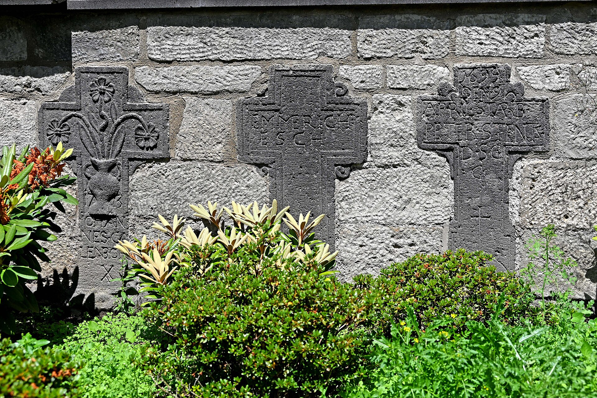 Historische Grabkreuze in der Kirchhofmauer von St. Hubertus in Rieden