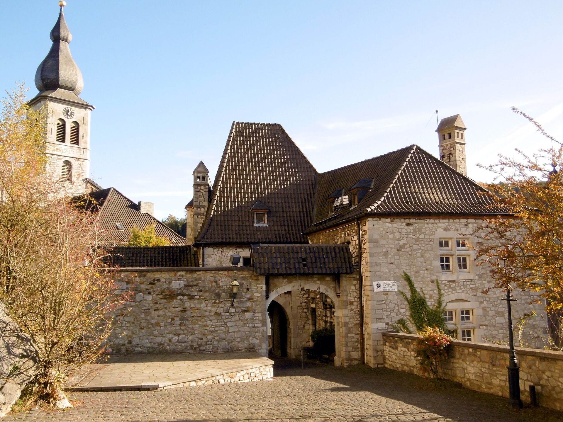 Innenhof der Vorburg von Burg Stolberg mit Torbogen zur Torburg, dahinter der Turm von St. Lucia.