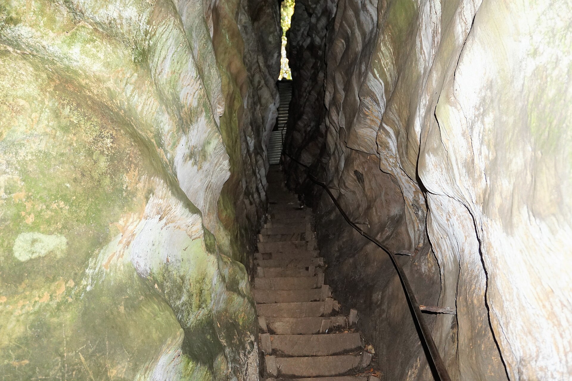 Schmale Treppe mit Geländer in einer hohen, engen Spalte im Sandsteinfelsen Perekop bei Berdorf.